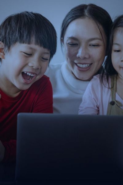 Children laughing while watching a show with a parent