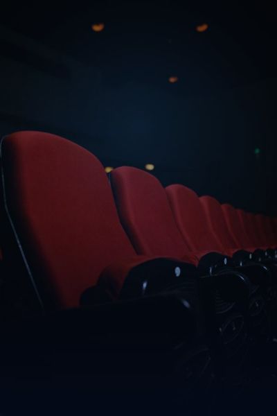Rows of red seats in a darkened cinema auditorium